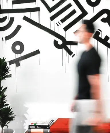 Someone crossing the office past the artwork.
